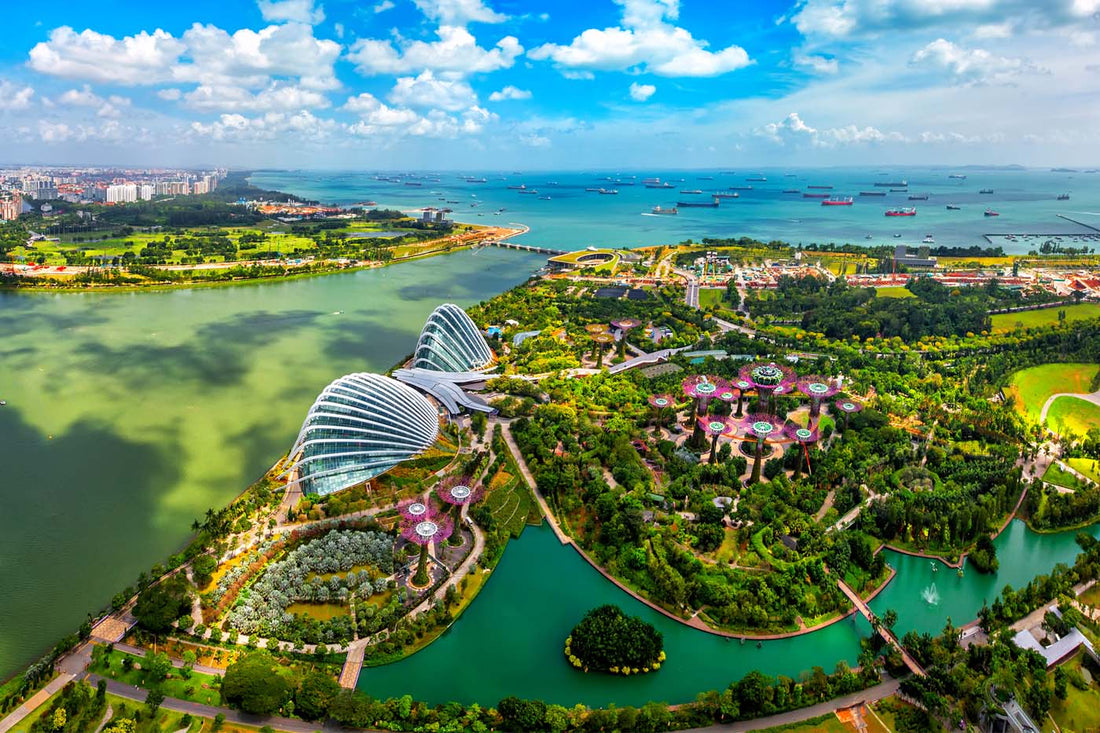 Aerial view of Gardens by the Bay in Singapore, featuring futuristic domes, Supertree Grove, lush greenery, and the Marina Bay waterfront.